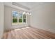 Bright dining room featuring hardwood floors, a modern chandelier, and large windows at 250 Ellington Rd, Graham, NC 27253