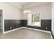 An elegant dining room is enhanced with wood paneling, a modern chandelier, and a large bright window at 250 Ellington Rd, Graham, NC 27253
