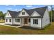 Charming white farmhouse with black shutters, a modern entrance and manicured landscaping at 250 Ellington Rd, Graham, NC 27253