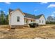 New construction featuring white siding, dark roof, front porch, and expansive unfinished yard at 250 Ellington Rd, Graham, NC 27253