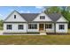 Charming white farmhouse with black shutters, a modern entrance and well-maintained landscaping at 250 Ellington Rd, Graham, NC 27253