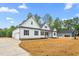 Beautiful white farmhouse-style home with black shutters, a spacious driveway, and a well-manicured lawn at 250 Ellington Rd, Graham, NC 27253