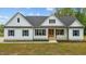 Charming white farmhouse with black shutters, a modern entrance and well-maintained landscaping at 250 Ellington Rd, Graham, NC 27253
