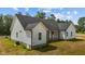 Exterior home elevation with white siding, dark roof and a well-manicured lawn at 250 Ellington Rd, Graham, NC 27253
