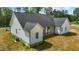 Rear exterior of a home with white siding, a dark roof, and a green lawn at 250 Ellington Rd, Graham, NC 27253