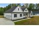 Bright white farmhouse with an attached garage, long driveway, and meticulously kept landscaping at 250 Ellington Rd, Graham, NC 27253