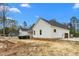 New construction home featuring white siding, dark roof, and expansive yard with construction debris at 250 Ellington Rd, Graham, NC 27253