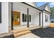 Inviting front porch with stained wood double doors, brick steps, and black support columns at 250 Ellington Rd, Graham, NC 27253