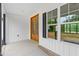 Cozy front porch featuring stained wood doors, white siding, and natural light through the windows at 250 Ellington Rd, Graham, NC 27253