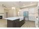 Open kitchen design with a large island, farmhouse sink, stainless appliances and an adjacent living area at 250 Ellington Rd, Graham, NC 27253