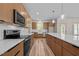 Bright kitchen with wooden cabinetry, quartz countertops, stainless appliances and hardwood floors at 250 Ellington Rd, Graham, NC 27253