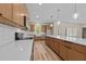 Bright kitchen featuring wooden cabinetry, quartz countertops, stainless appliances, and hardwood floors at 250 Ellington Rd, Graham, NC 27253