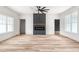 Open living space with hardwood floors, a dark fireplace, and plenty of natural light from large windows at 250 Ellington Rd, Graham, NC 27253