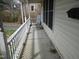 Inviting front porch features white railing, a rocking chair, and space for relaxing at 306 Eastway Ln, Graham, NC 27253