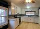 Bright kitchen with white cabinets, stainless steel appliances, and light wood floors at 3077 Christian Light Road Rd, Fuquay Varina, NC 27526