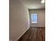 A simple bedroom with modern flooring and a bright single window at 3271 Roundly Rd # 9, New Hill, NC 27562