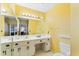 Bathroom with double vanity, toilet, and yellow walls at 3872 Hope Valley Rd, Durham, NC 27707