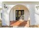 Elegant arched entryway with a black door and sidelights at 3872 Hope Valley Rd, Durham, NC 27707