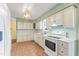 Updated kitchen features white cabinets, tile flooring, and stainless steel appliances at 3872 Hope Valley Rd, Durham, NC 27707