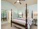 Spacious bedroom with a large four-poster bed and ensuite bathroom access at 401 Streamwood Dr, Holly Springs, NC 27540