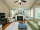 Spacious living room featuring a fireplace and a comfy green sofa at 401 Streamwood Dr, Holly Springs, NC 27540