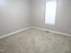 Simple carpeted bedroom with neutral walls and window at 409 James Toney Dr, Elon, NC 27244