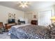 Spacious bedroom with a comfortable bed, a cozy seating area, and a ceiling fan at 5101 Hogans Way, Clayton, NC 27520