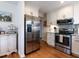 Well-equipped kitchen featuring stainless steel appliances, ample cabinetry, granite counters and hardwood flooring at 5101 Hogans Way, Clayton, NC 27520