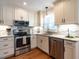 Bright, updated kitchen with stainless steel appliances, granite countertops, and custom cabinets on hardwood floors at 5101 Hogans Way, Clayton, NC 27520