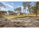 Wide backyard featuring a two-story home with a deck, fully fenced perimeter, and green grass and trees at 539 Long Grass Dr, Smithfield, NC 27577