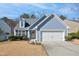 Charming home featuring a well-manicured lawn, blue siding, and an attached two-car garage at 701 Brickstone Dr, Apex, NC 27502