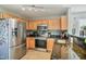 Kitchen featuring stainless steel appliances, granite countertops, and natural wood cabinets at 701 Brickstone Dr, Apex, NC 27502