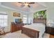 A bright, spacious bedroom with a ceiling fan and a decorative painting above the bed at 701 Brickstone Dr, Apex, NC 27502