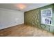 A stylish bedroom features hardwood floors, decorative green wall, and a bright window at 727 Cook Rd, Durham, NC 27713