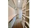 Bright walk-in closet featuring built-in shelves, hanging rods, and neutral carpeting at 727 Cook Rd, Durham, NC 27713