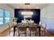 Dining room with black accent wall, hardwood floors, a modern chandelier, and seating for eight at 727 Cook Rd, Durham, NC 27713