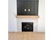 Living room fireplace featuring a marble hearth, wooden mantle and black paneled accent wall above the fireplace at 727 Cook Rd, Durham, NC 27713