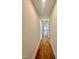 Hallway featuring hardwood floors with doors and a view of a decorative wall at the end at 727 Cook Rd, Durham, NC 27713