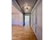 Elegant gray hallway featuring wainscoting, hardwood floors, and a view into a sunlit room at 727 Cook Rd, Durham, NC 27713