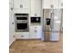 White kitchen cabinets with stainless steel appliances including a refrigerator and built-in oven at 727 Cook Rd, Durham, NC 27713