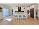Open kitchen with white cabinetry, stainless steel appliances, tile backsplash, an island, hardwood floors, and seating at 727 Cook Rd, Durham, NC 27713