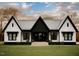 Stunning modern farmhouse with black and white exterior, landscaping, and large windows at Lot 18H Good Shepherd Trl, Spring Hope, NC 27882
