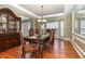 Formal dining room with hardwood floors, elegant chandelier, and large bay window offers a sophisticated dining experience at 101 Quarryrock Rd, Holly Springs, NC 27540