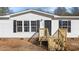 Close up of the front entrance of a white single-story home with black shutters at 102 Anderson Dr, Wake Forest, NC 27587