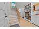 Hallway featuring stairs, light wood flooring, and built-in bookshelves filled with books at 114 Spring Blossom Ln, Durham, NC 27705