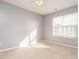 Well-lit bedroom with neutral carpeting, light-blue painted walls, and a bright, natural-light window at 125 Watertree Ln, Apex, NC 27502