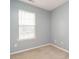 Cozy bedroom with neutral carpeting, light-blue painted walls, and a bright, natural-light window at 125 Watertree Ln, Apex, NC 27502