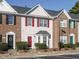 Charming townhome with brick and vinyl siding, colorful shutters and a well-maintained yard at 125 Watertree Ln, Apex, NC 27502
