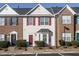 Charming townhome featuring red shutters, bay window, manicured landscaping, and convenient parking at 125 Watertree Ln, Apex, NC 27502