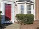 Close up of townhome entrance with red door, bay window, and well-maintained landscaping at 125 Watertree Ln, Apex, NC 27502